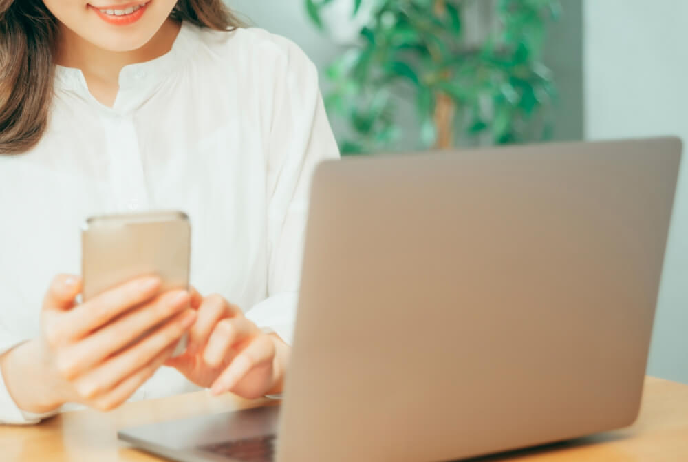 パソコンとスマートホンを操作する女性